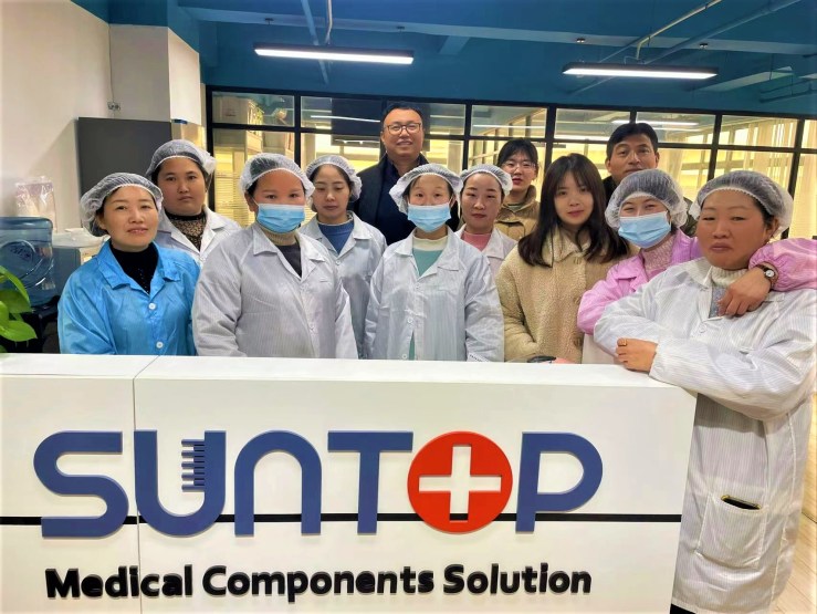 Colin Zhao and his staff stand behind the sign reading "Suntop Medical Parts Solution."