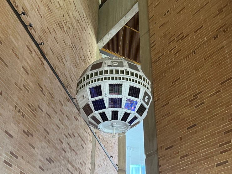 A Telstar 1 backup outer  hangs suspended successful  Bell Labs' showroom. It's a achromatic  sphere with star  panels each  on  the outside.