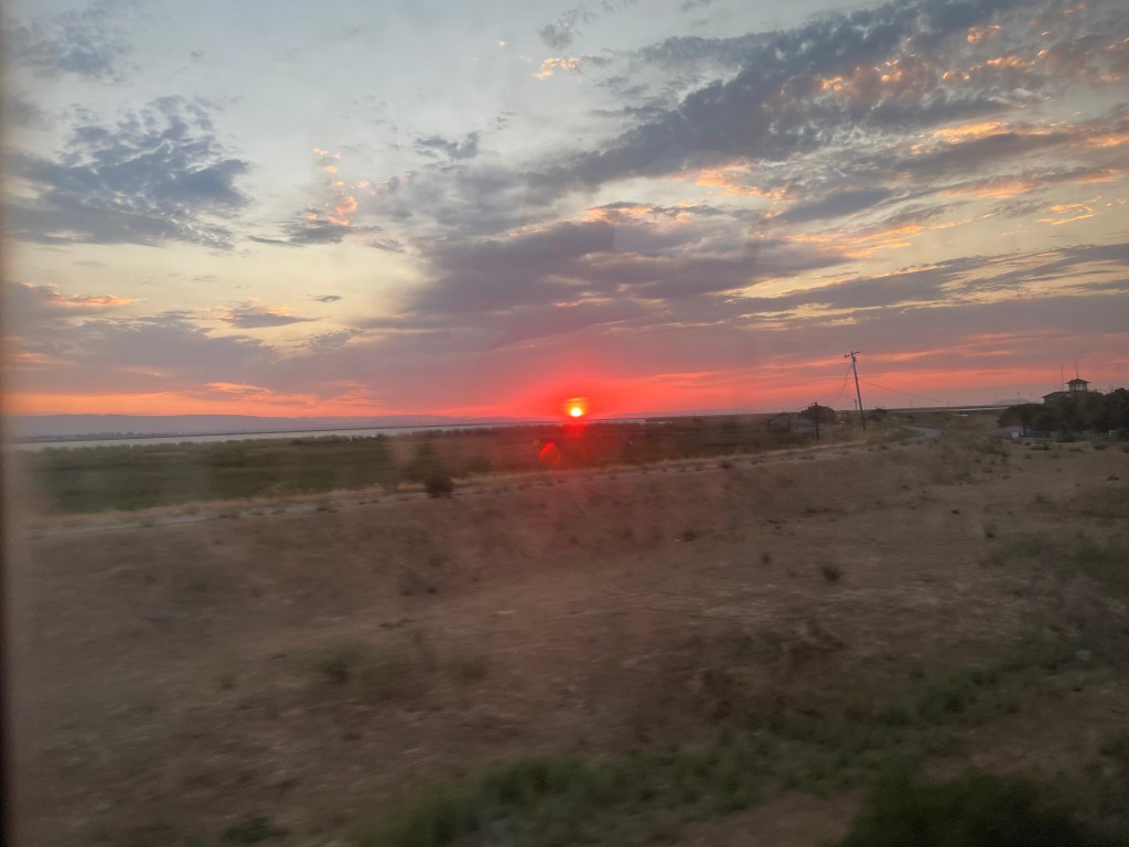 A sunset seen from the window of an Amtrak train.