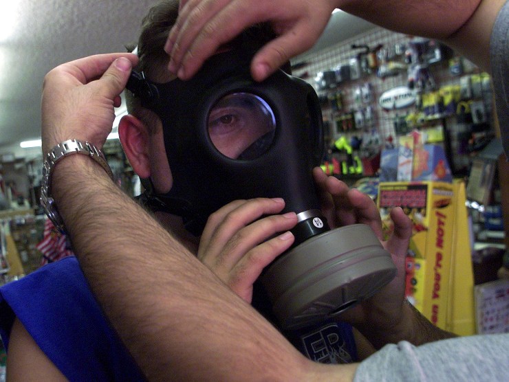 A person is fitted for a gas mask at an emergency preparedness store. 