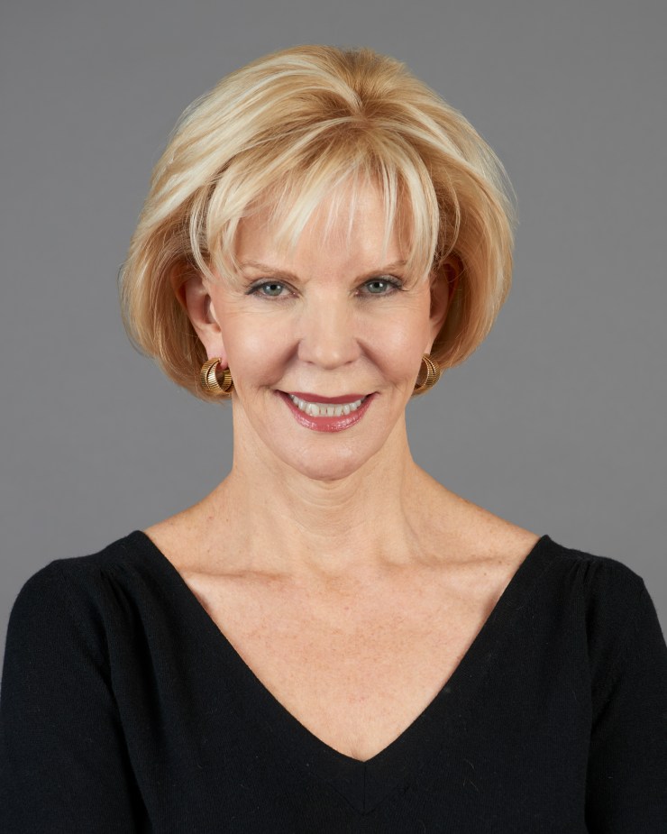 A headshot of a woman wearing a black top.