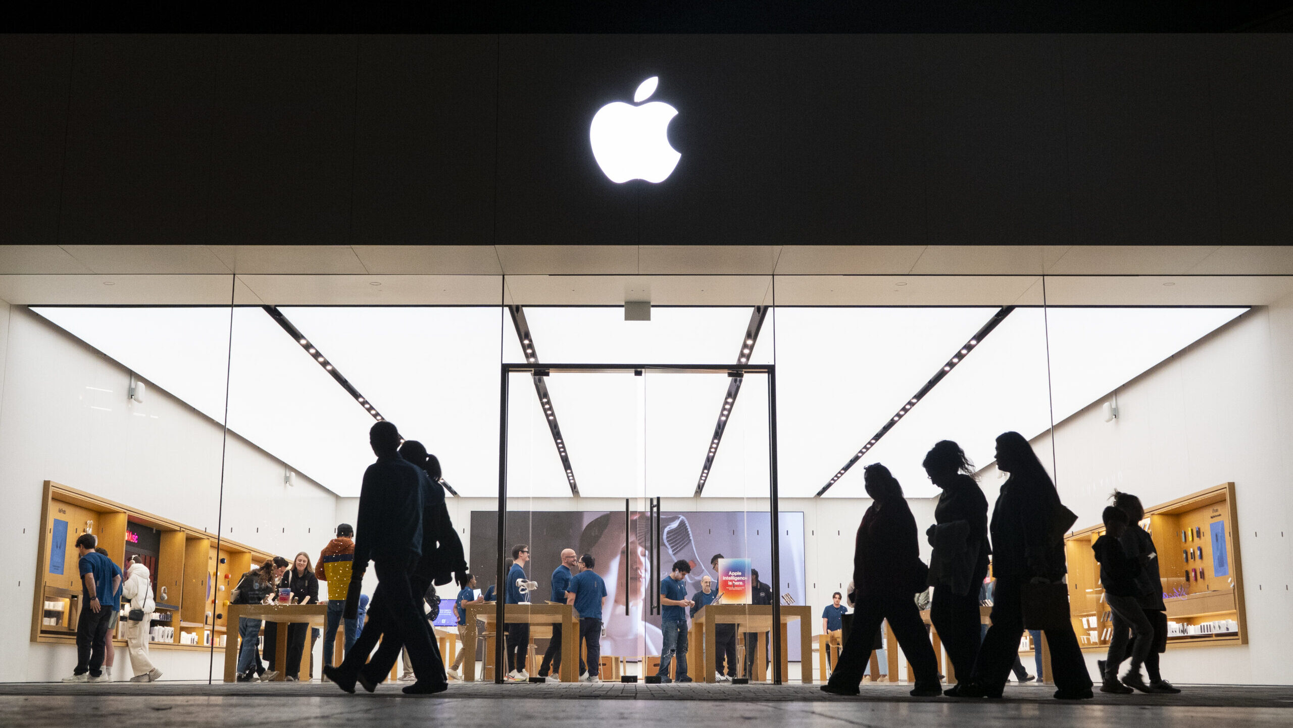 people walking in line in front of an apple store